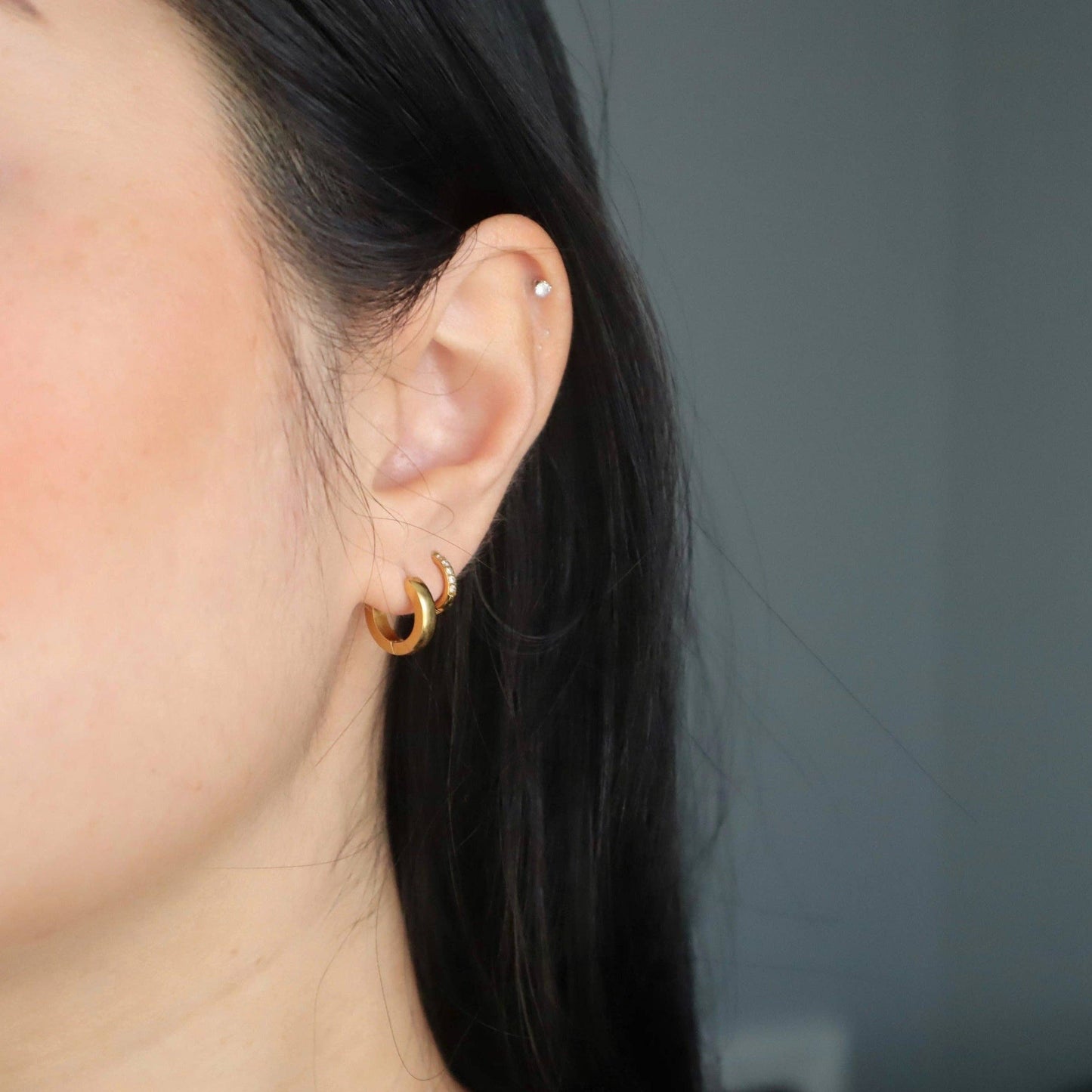 JESSA Jewelry Sadie hoops worn stacked on model’s ear, shown in natural lighting for realistic sizing.