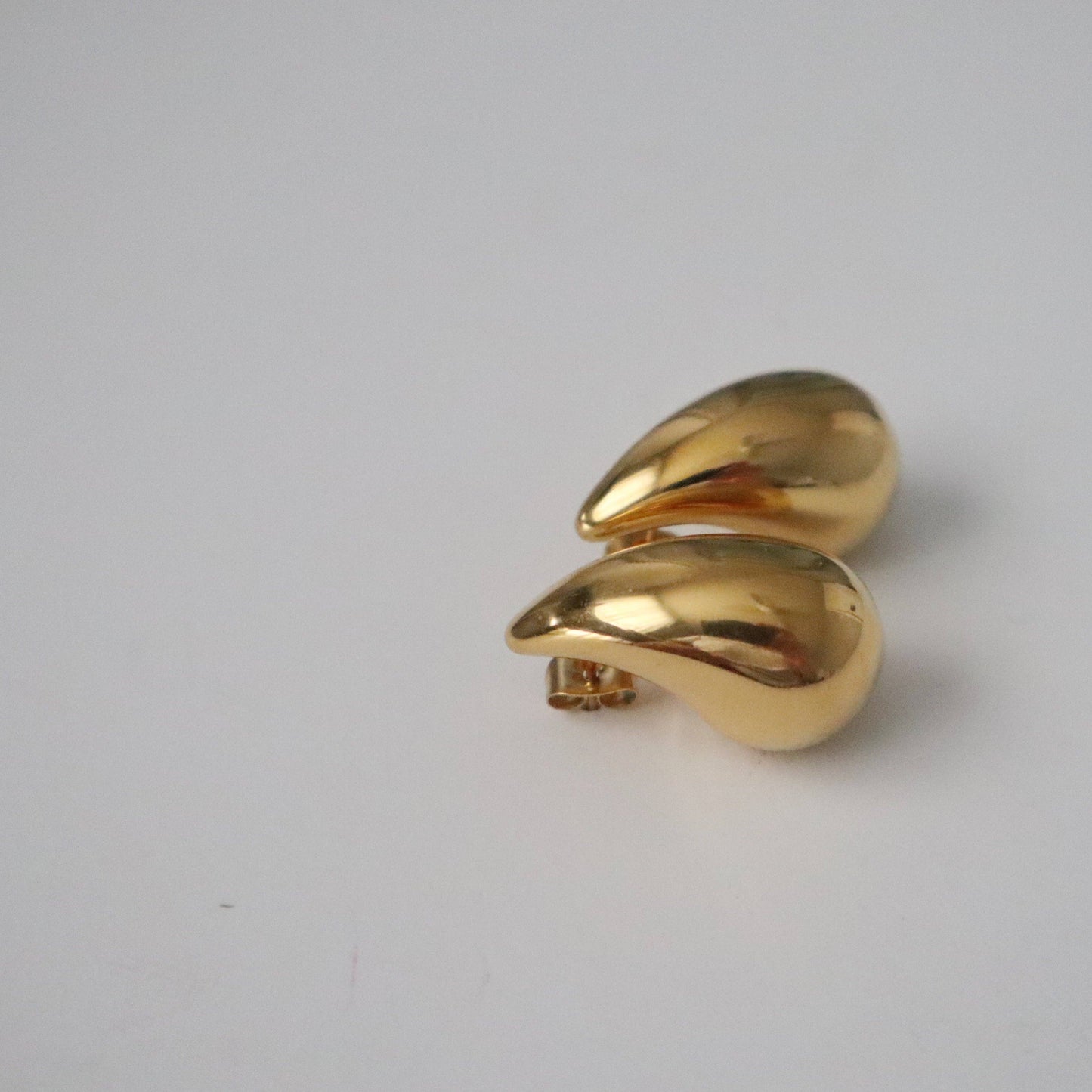 Side profile view of stacked JESSA Jewelry Waterdrop Earrings showing sculptural curve.