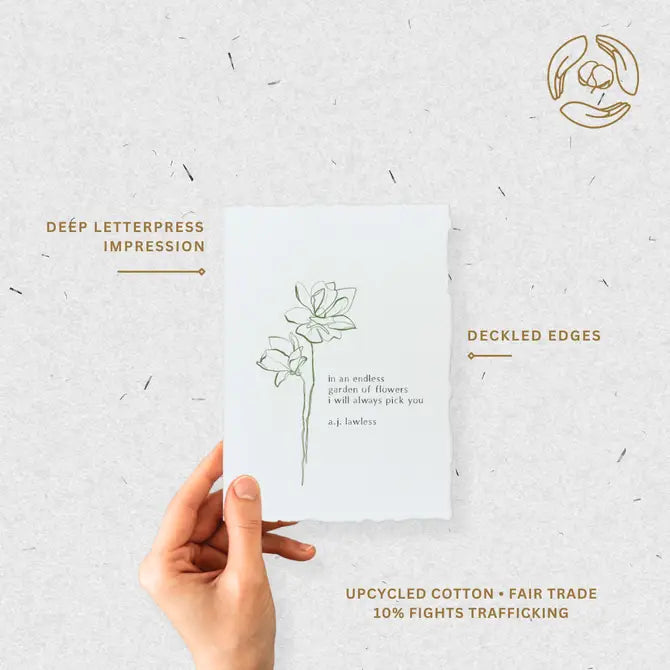 Hand holding eco-friendly greeting card highlighting deep letterpress impression, deckled edges, and fair-trade cotton paper.