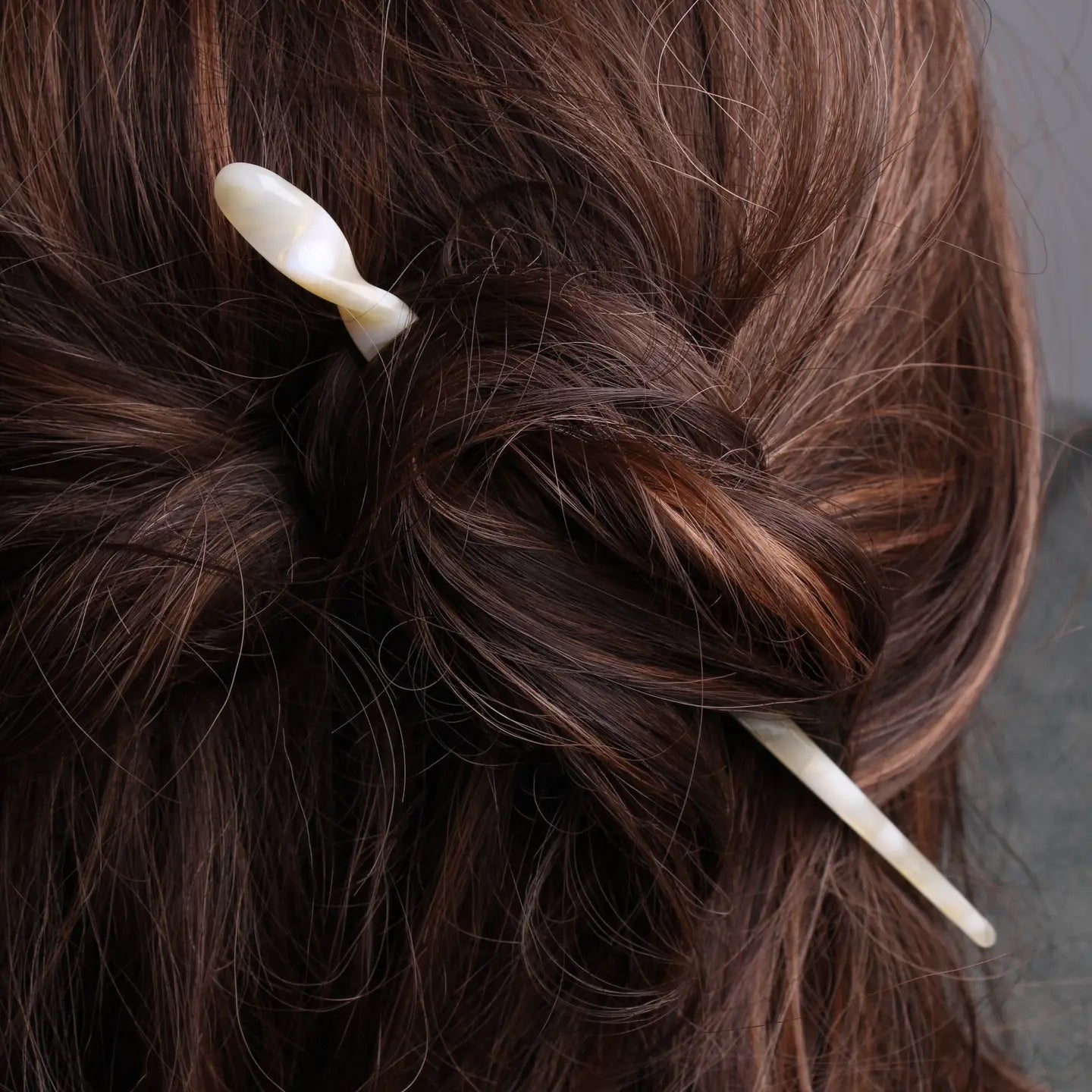 Nougat Peignée Paris hair stick pin securing half up twisted bun in brunette hair.