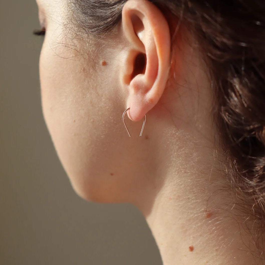 Closeup of woman wearing Token Jewelry Mini Horseshoe Earrings from side profile view.