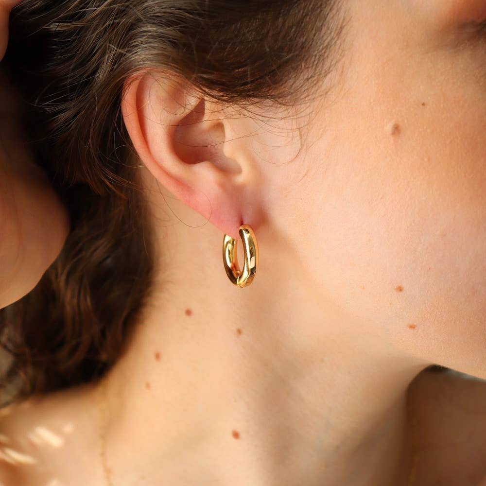 Side profile view of Token Jewelry Everyday Hoops gold earrings worn by model.