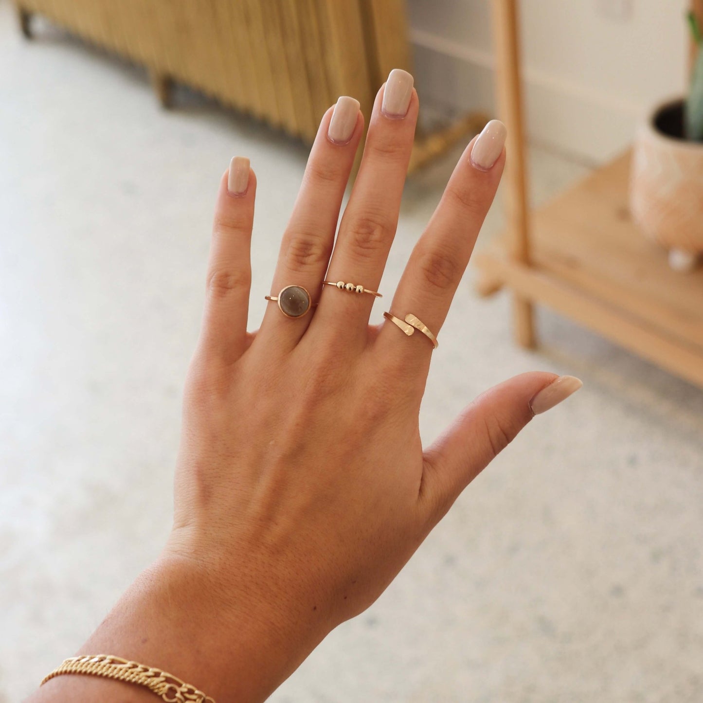 Gold Token Jewelry Meridian Fidget Ring worn with other rings, hand and wrist closeup.