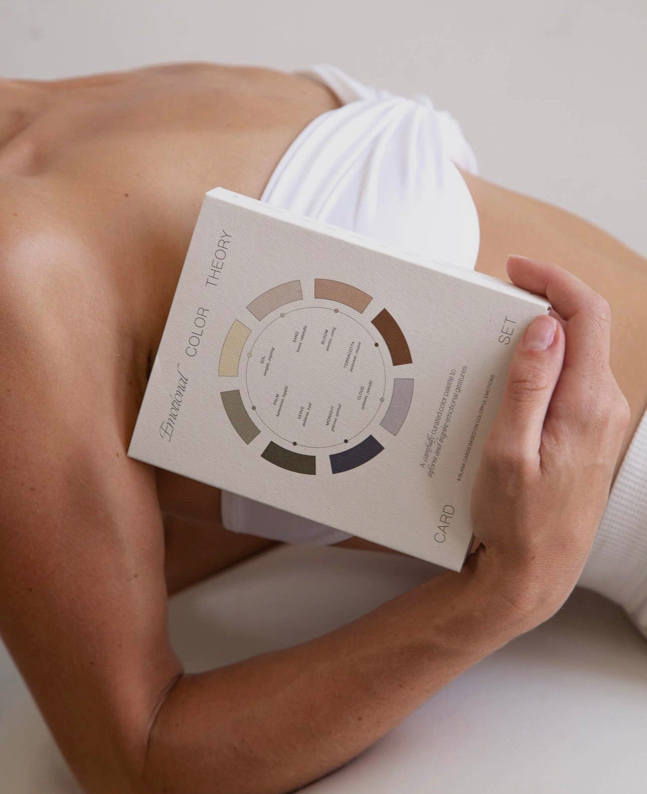 Person holding the Wilde House Paper Emotional Color Theory Card Set while lying down, minimal and serene aesthetic.