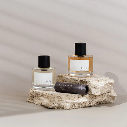 But First balm by Orchid & Ash styled with Aura and Idyll perfumes on stacked textured stone.