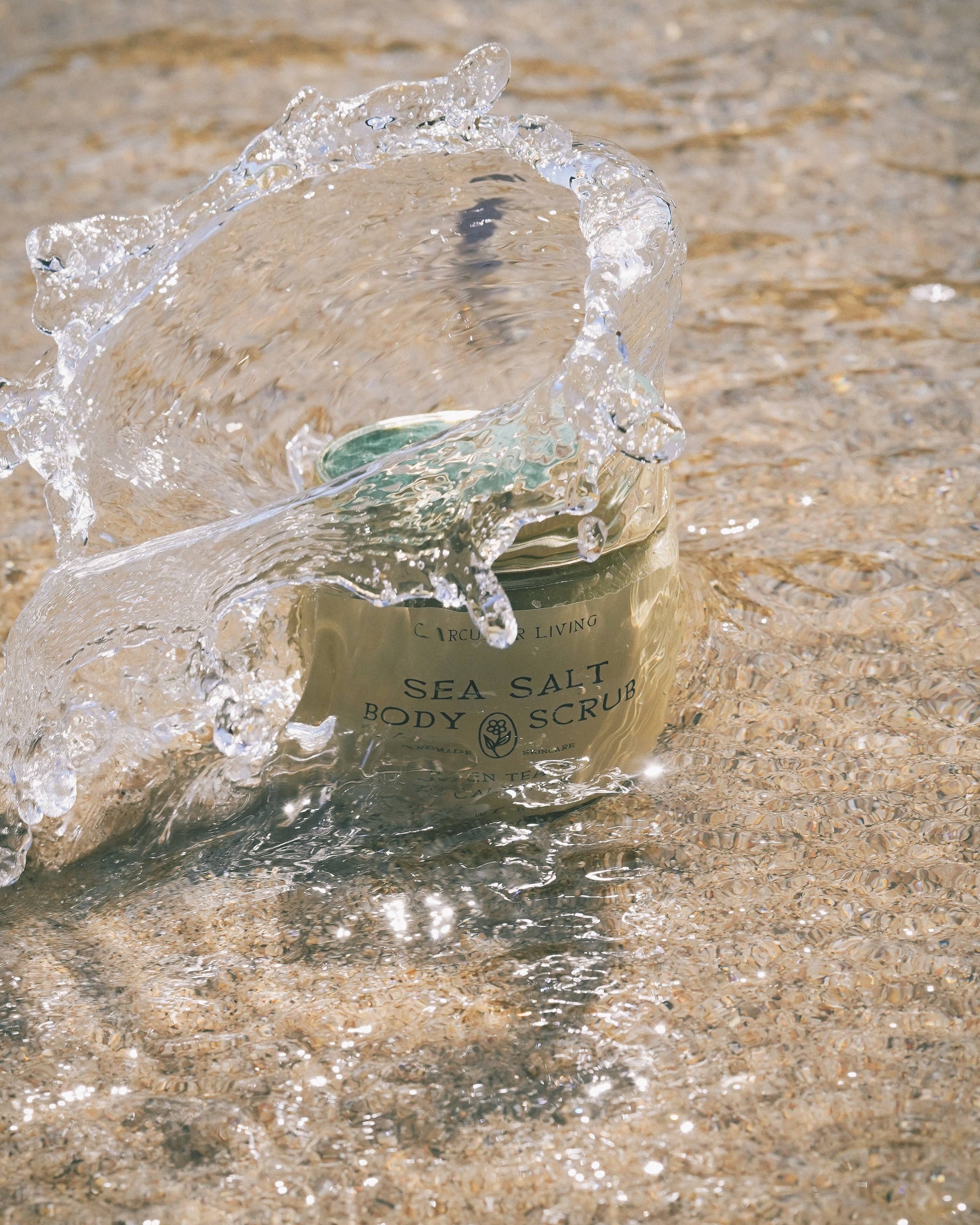 Circular Living Sea Salt Body Scrub with Green Tea and Eucalyptus splashed with water, handmade clean beauty.