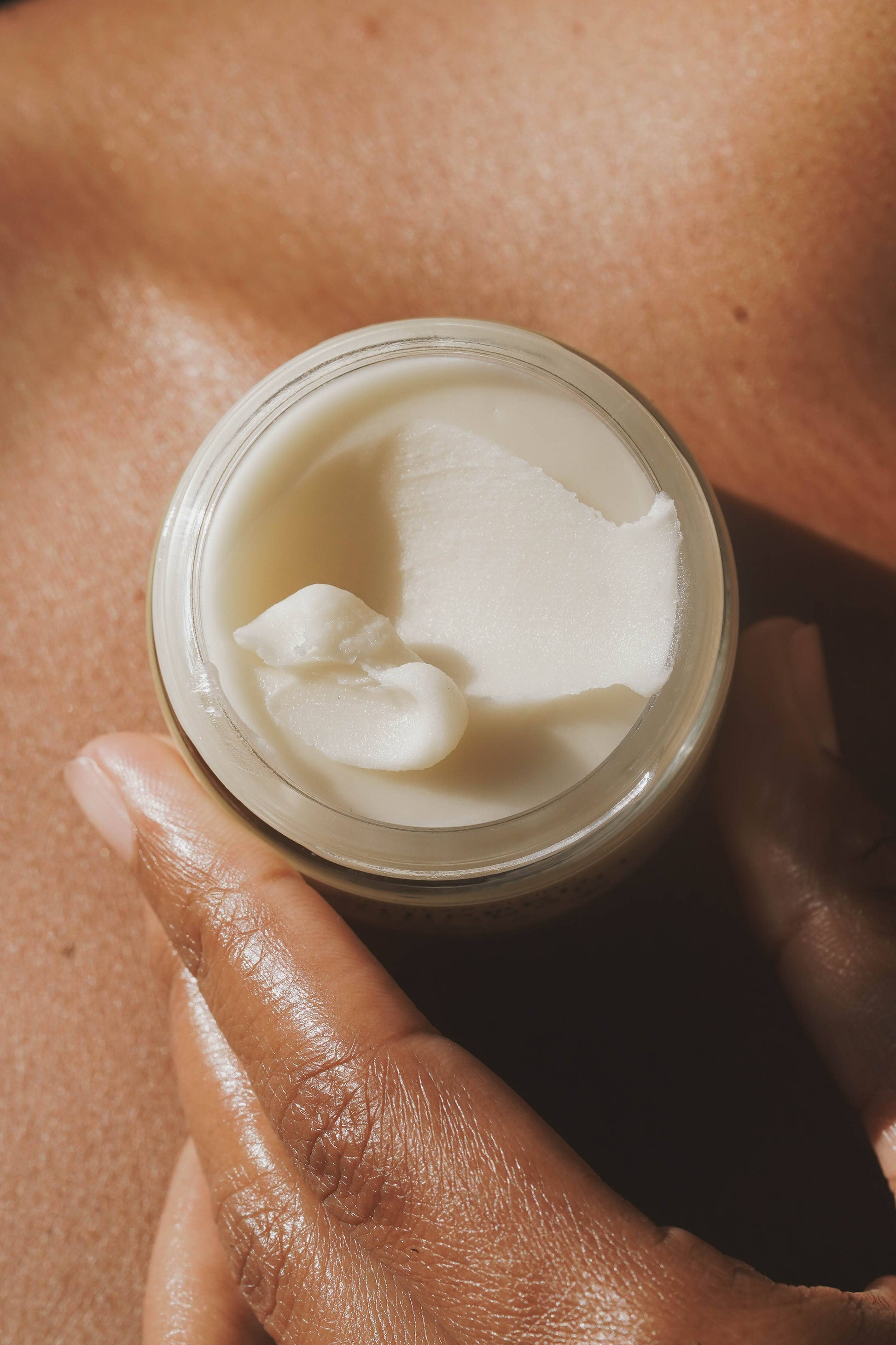 Open jar of Circular Living Whipped Deodorant Gentle Unscented held in hand showing creamy texture.