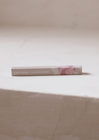 Daily Habits Reflexology Wand box resting on a stone surface.
