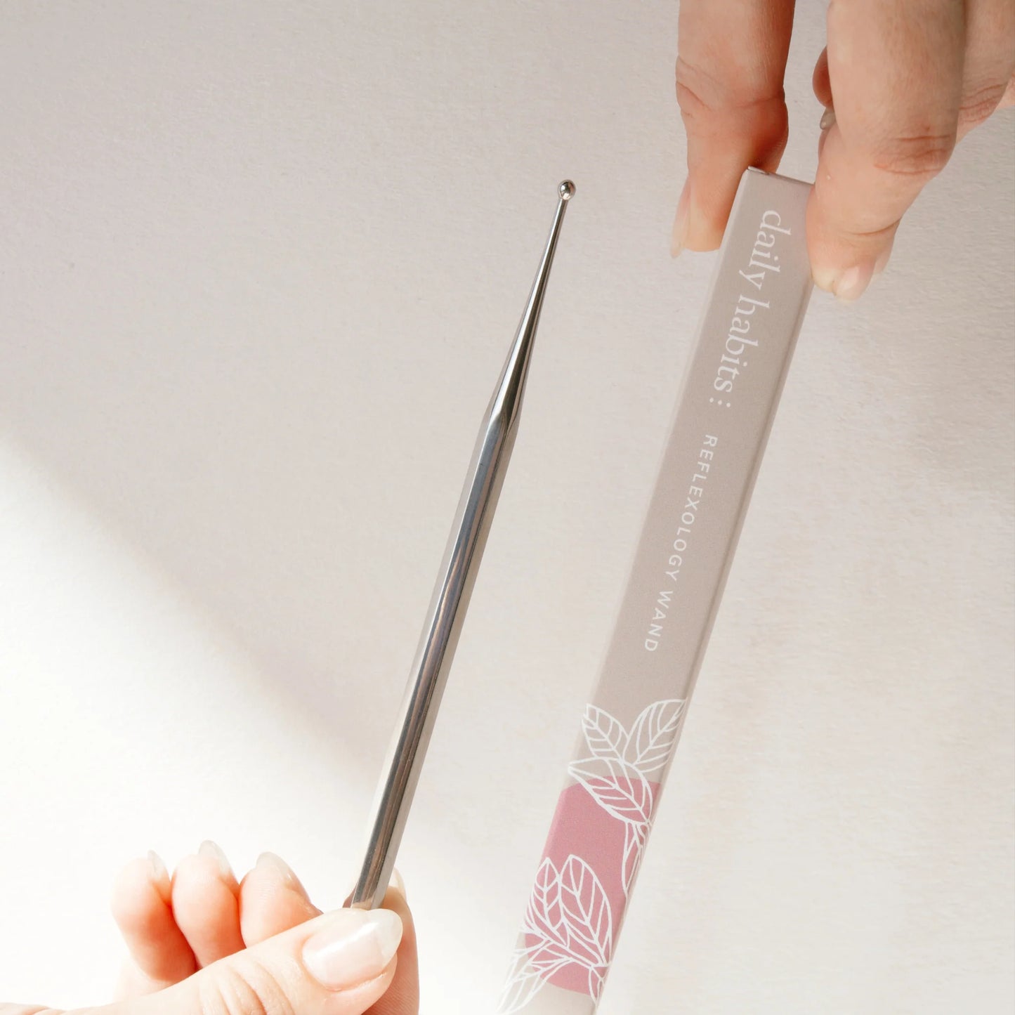 Close-up of Daily Habits Facial Reflexology Tool and box on neutral surface.