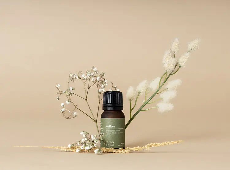 Fern & Petal Willow Essential Oil bottle displayed on a neutral background with babys breath, straw and cotton.