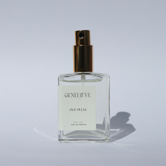 Bottle of Genevieve Fragrances Oud Plum limited edition perfume with gold spray top on white background.