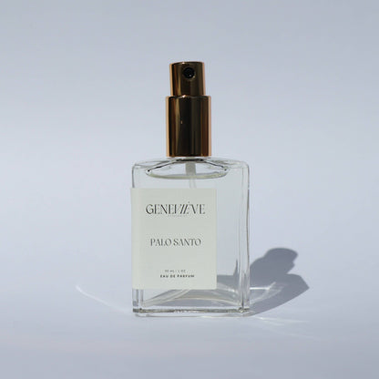 Geneviève Palo Santo Eau de Parfum bottle with spray nozzle open on a white background.