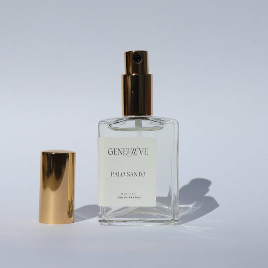 Geneviève Palo Santo Eau de Parfum bottle with gold cap placed beside it on a white background.