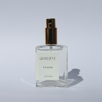 Geneviève Toujours Eau de Parfum bottle with spray nozzle open on a white background.