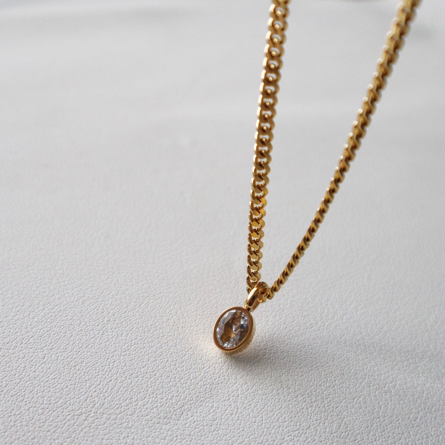 Side angle of JESSA Jewelry chain necklace showing gem detail and gold setting.