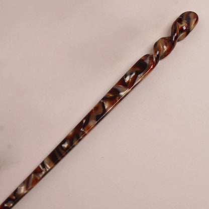 Long espresso-colored twisted Peignée Paris hair stick pin with a glossy, smooth finish.