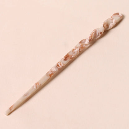 Full view of the Peignée Paris hair stick pin in nougat shade laid flat over neutral background.