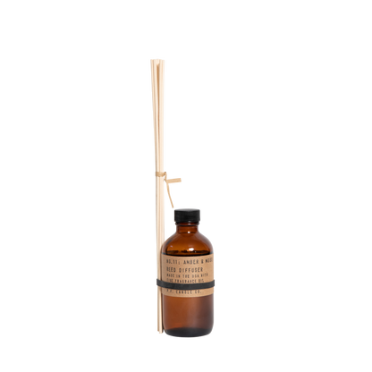 P.F. Candle Co. Amber & Moss reed diffuser with bundled diffuser sticks tied to the bottle.
