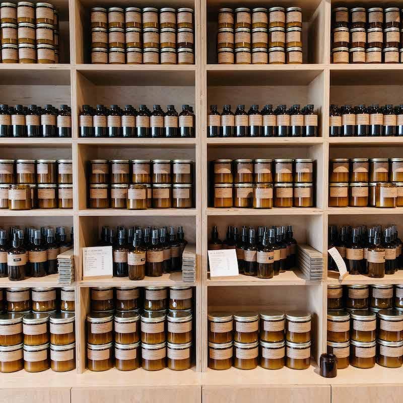 Wooden shelves fully stocked with P.F. Candle Co. products including diffusers, candles, and sprays.