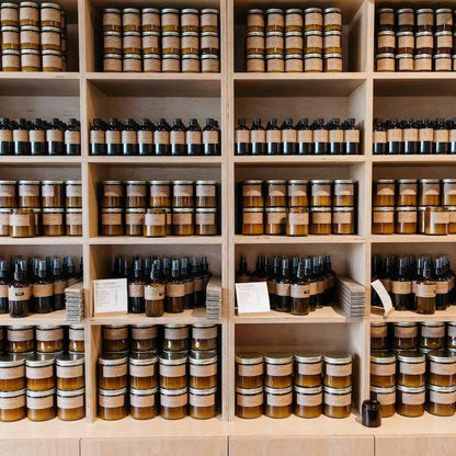 Wooden shelves fully stocked with P.F. Candle Co. products including diffusers, candles, and sprays.