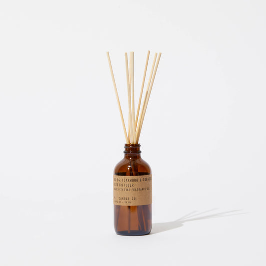 P.F. Candle Co. Teakwood & Tobacco reed diffuser in amber glass bottle against a white background.