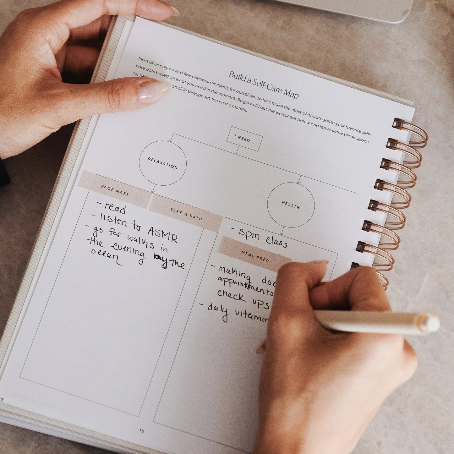 Person writing in The Self Care Planner's build-a-self-care-map page, brainstorming daily habits and wellness ideas.