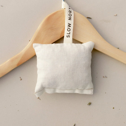 Slow North Lavender and Cedar Sachet hanging on a wooden clothes hanger, labeled as a best seller.