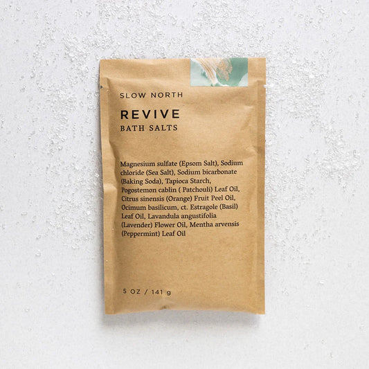 Slow North Revive Bath Salts pouch laid flat on a light textured surface, showing minimalist kraft packaging.