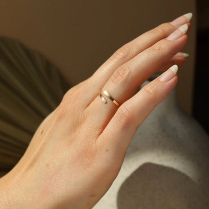Close-up of Token Jewelry Coil Ring in gold styled on hand.
