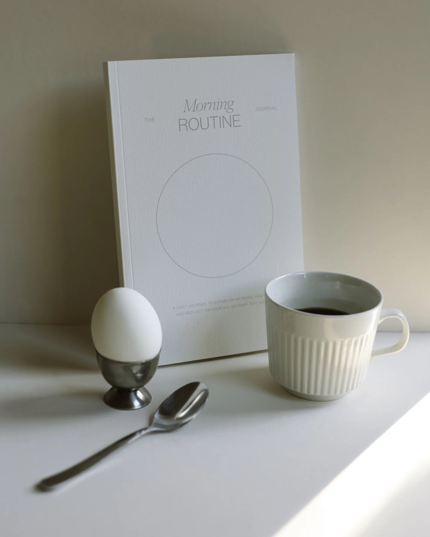 Wilde House Paper Morning Routine Journal styled with coffee and hard boiled egg on a breakfast table.