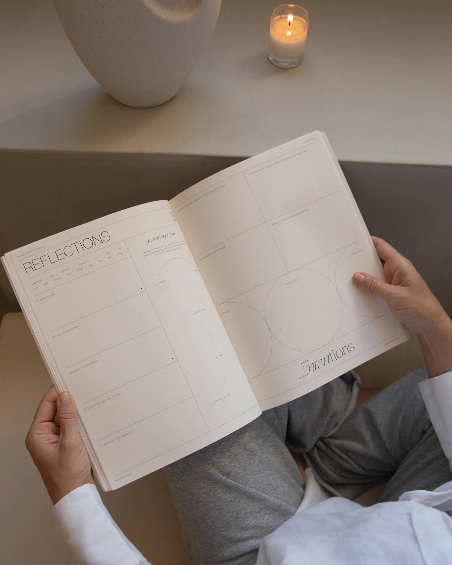 Open pages of The Reset Guide by Wilde House Paper showing reflections and intentions sections, held by a reader.