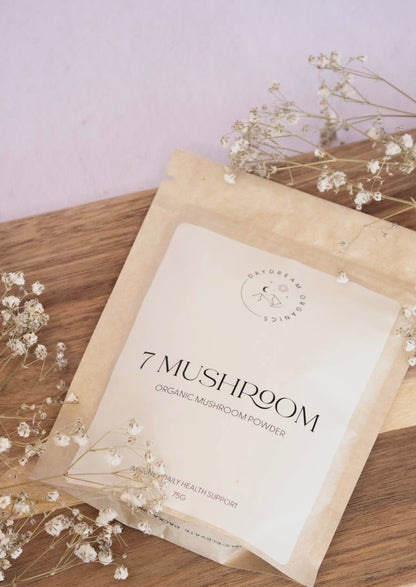 Daydream Organics 7 Mushroom Powder flatlay with baby’s breath flowers.