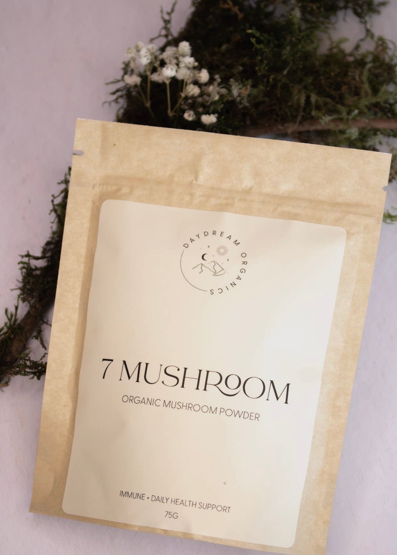 Daydream Organics 7 Mushroom Powder pouch with greenery background.