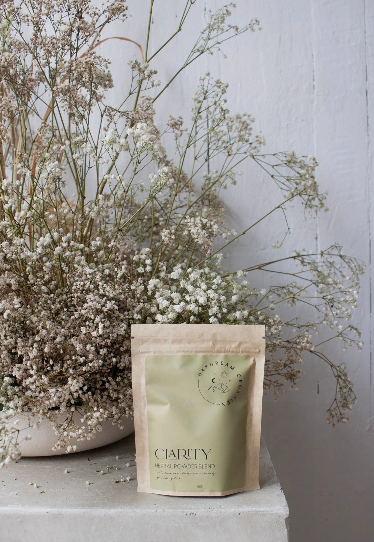 Daydream Organics Clarity Herbal Powder Blend styled with baby's breath flowers in a rustic setting.