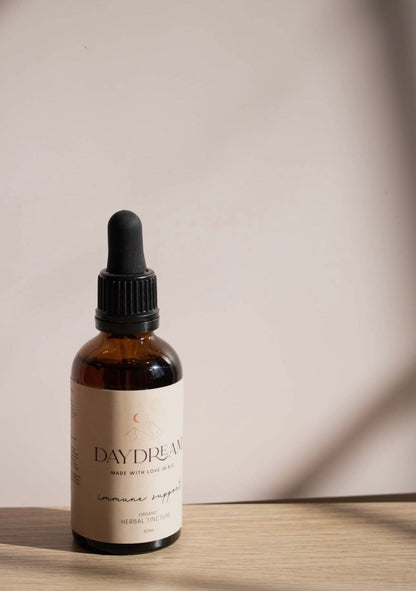 Close-up of Daydream Organics Immune Support Herbal Tincture bottle with sunlight shadows.