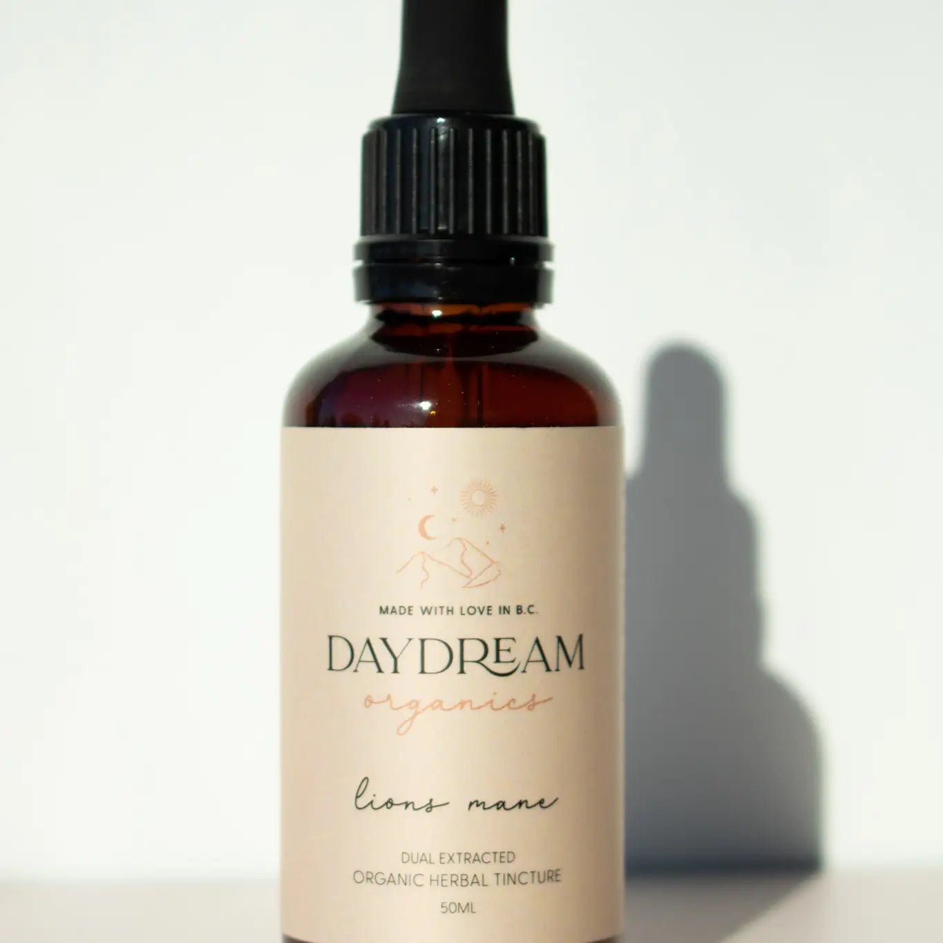 Lion’s Mane tincture bottle by Daydream Organics with soft natural light and shadow.