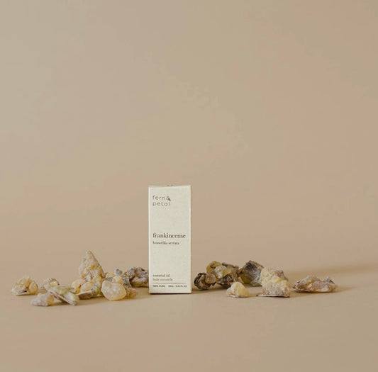 Fern & Petal Frankincense Essential Oil box surrounded by frankincense resin pieces on a neutral background.