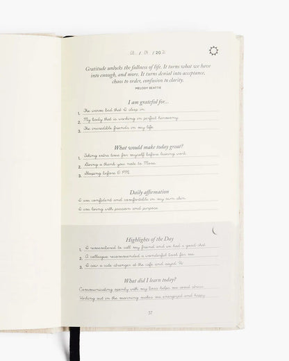 Open page of The Five Minute Journal showing daily gratitude and affirmation prompts.