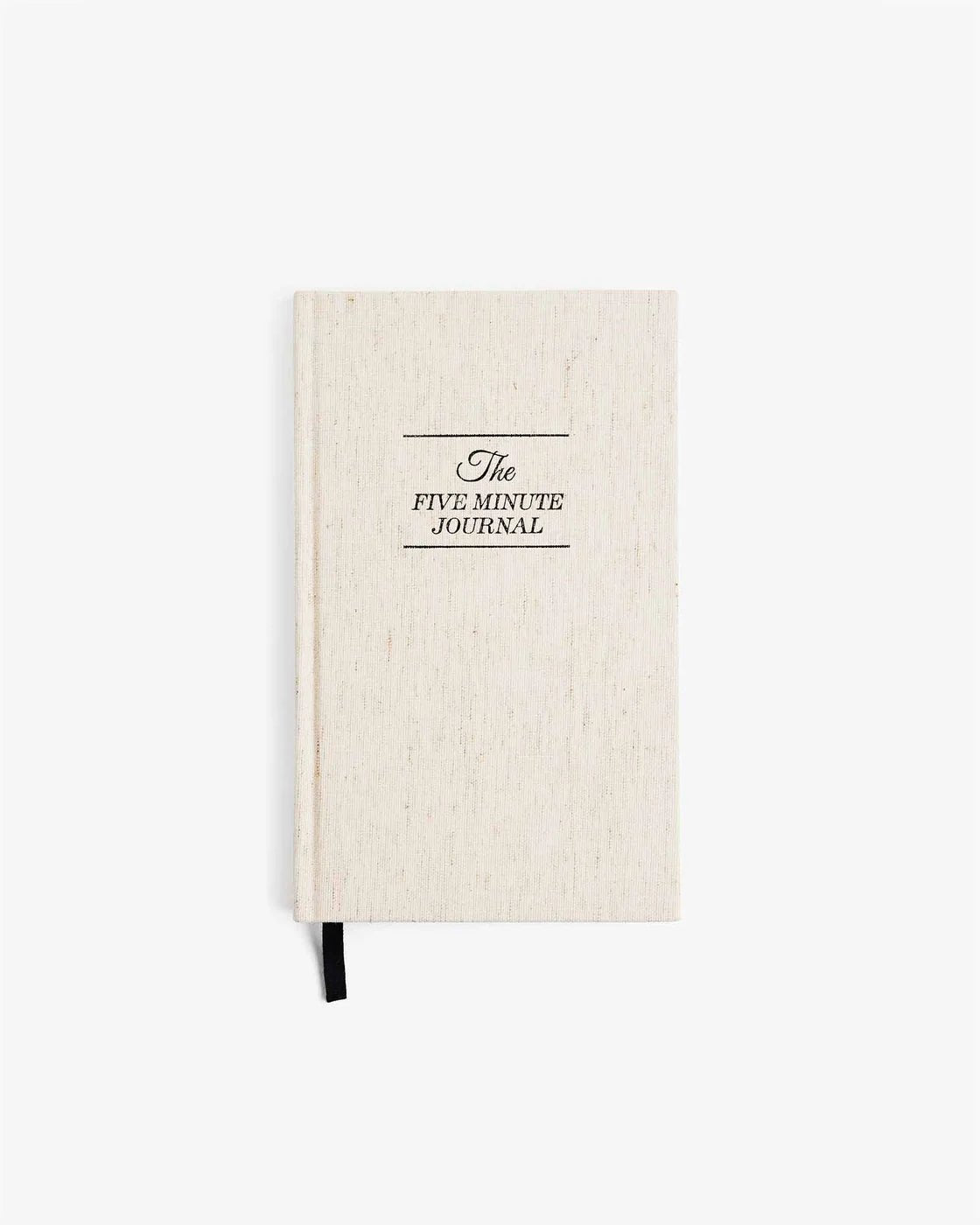 The Five Minute Journal with linen cover laid flat on white background, showcasing minimalist design.