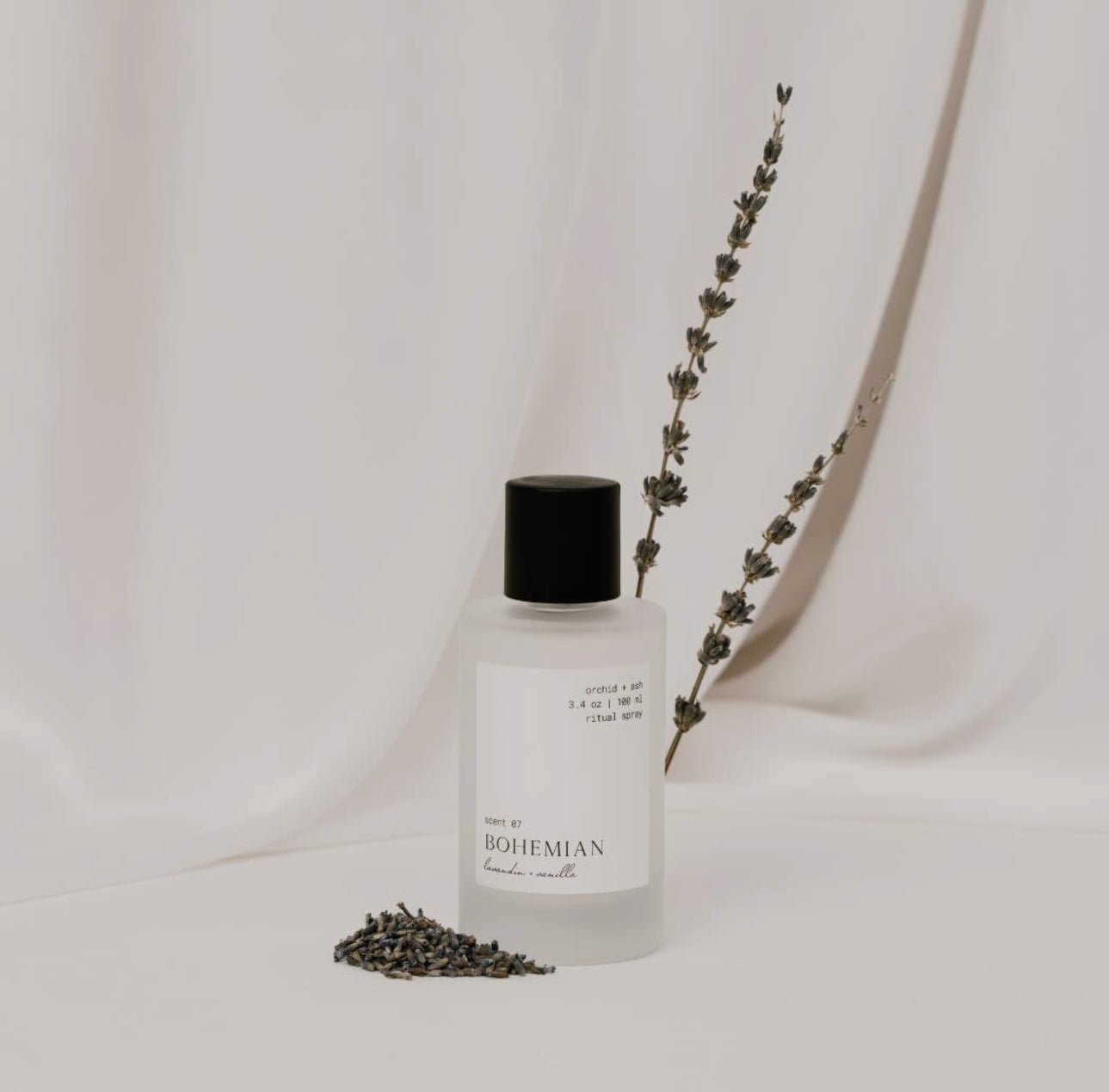 Bohemian room spray by Orchid & Ash standing beside dried lavender on a soft ivory backdrop.