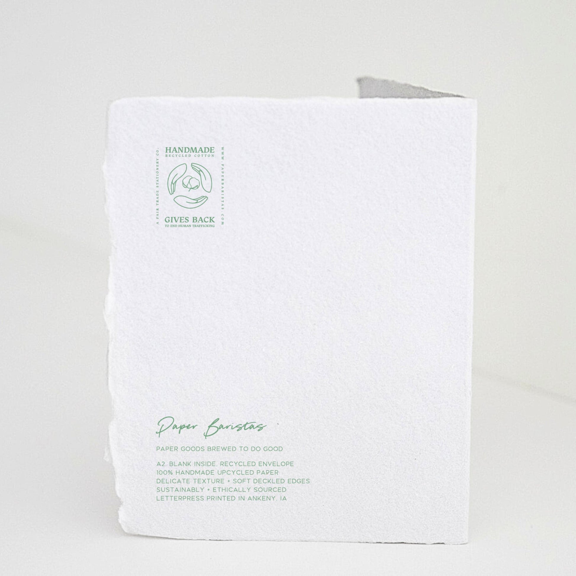 Back of Paper Baristas holiday "With Love and Peace" greeting card with letterpress details and ethical production message in green ink.