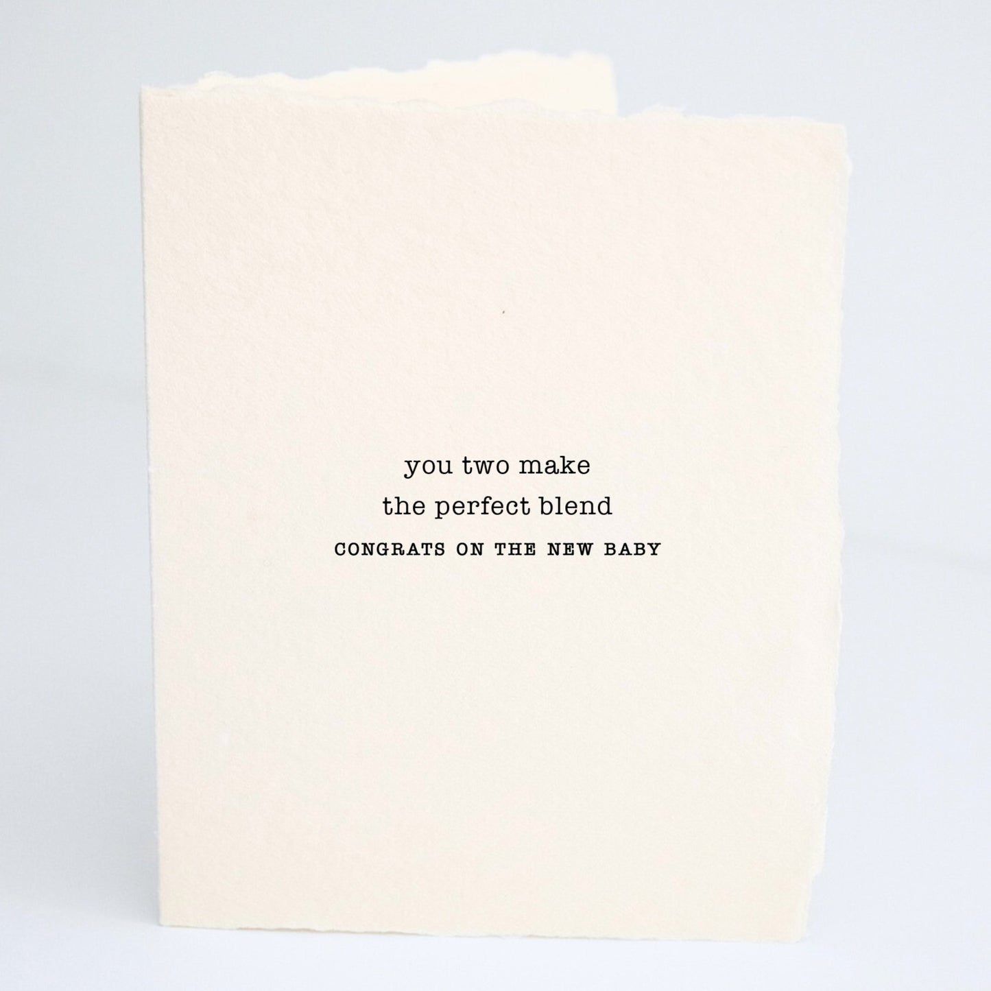 Front of Paper Baristas baby greeting card reading “You Two Make The Perfect Blend — Congrats On The New Baby” on textured cotton recycled paper in black ink.