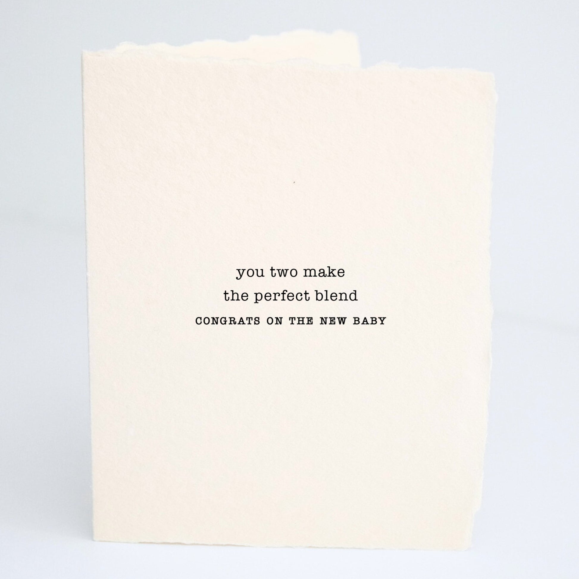 Front of Paper Baristas baby greeting card reading “You Two Make The Perfect Blend — Congrats On The New Baby” on textured cotton recycled paper in black ink.