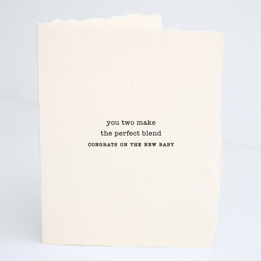 Front of Paper Baristas baby greeting card reading “You Two Make The Perfect Blend — Congrats On The New Baby” on textured cotton recycled paper in black ink.
