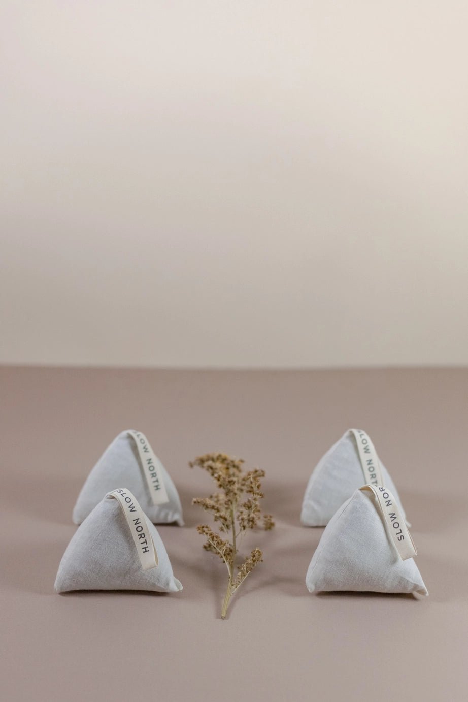 Set of four Slow North Cedar Sachets arranged in a group with a dried floral accent, styled on a neutral tabletop.