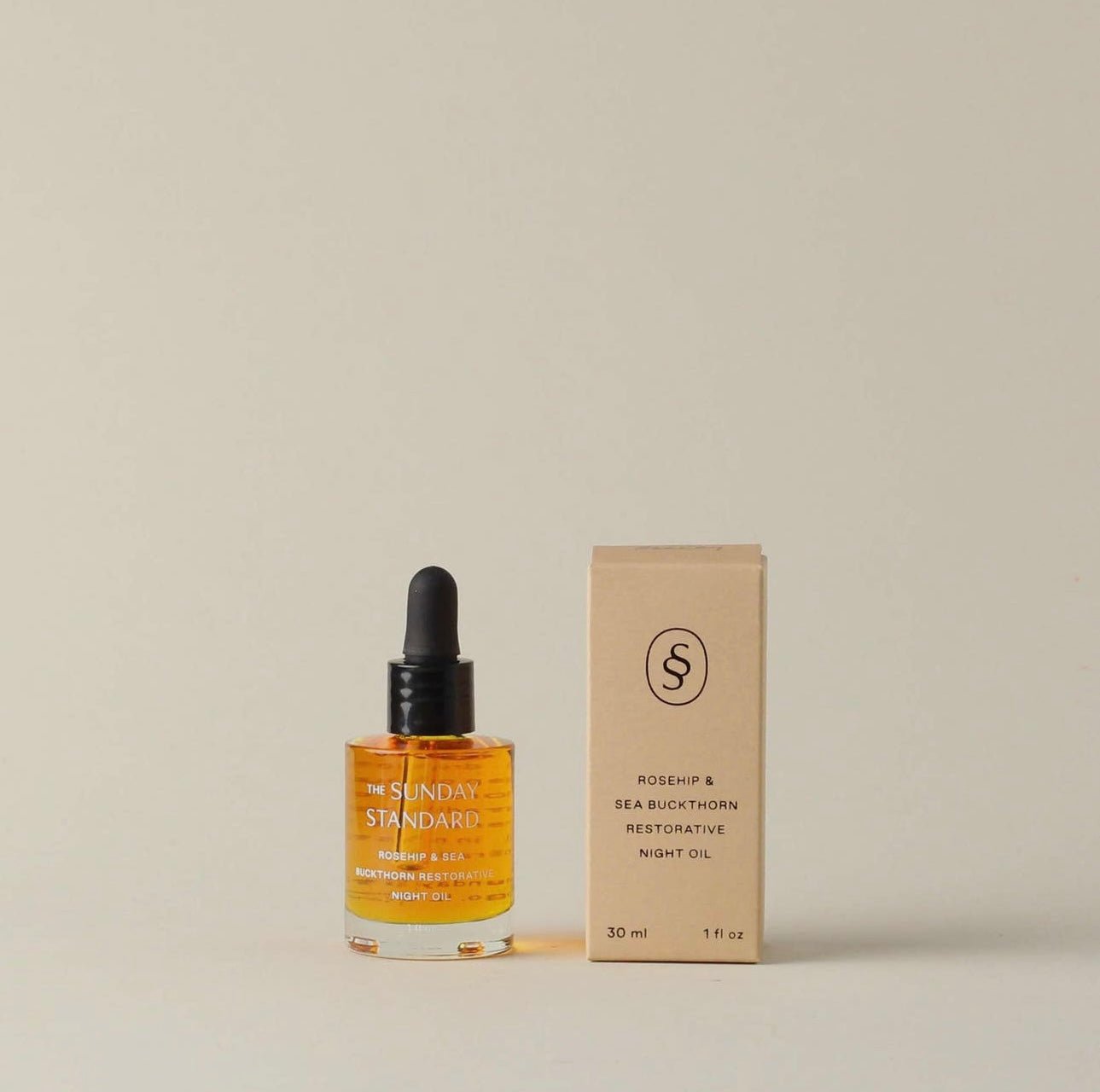 Front view of The Sunday Standard Rosehip & Sea Buckthorn Restorative Night Oil bottle next to its box.