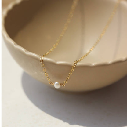 Token Jewelry Mini Pearl Necklace displayed in a neutral ceramic bowl.