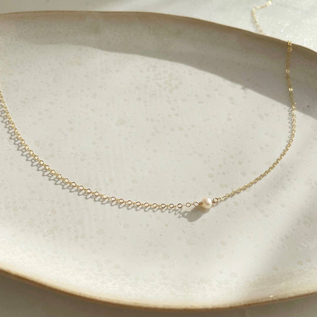 Token Jewelry Mini Pearl Necklace styled on white jewelry dish.