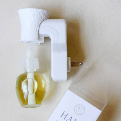 Well-Taylored Wall Diffuser Plug-In with fragrance refill and branded card.