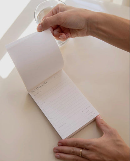 Person’s hands tearing a page from the Wilde House Paper To Do List Pad.